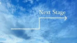 青空に白い階段と矢印が描かれ、「Next Stage」の文字が入った画像