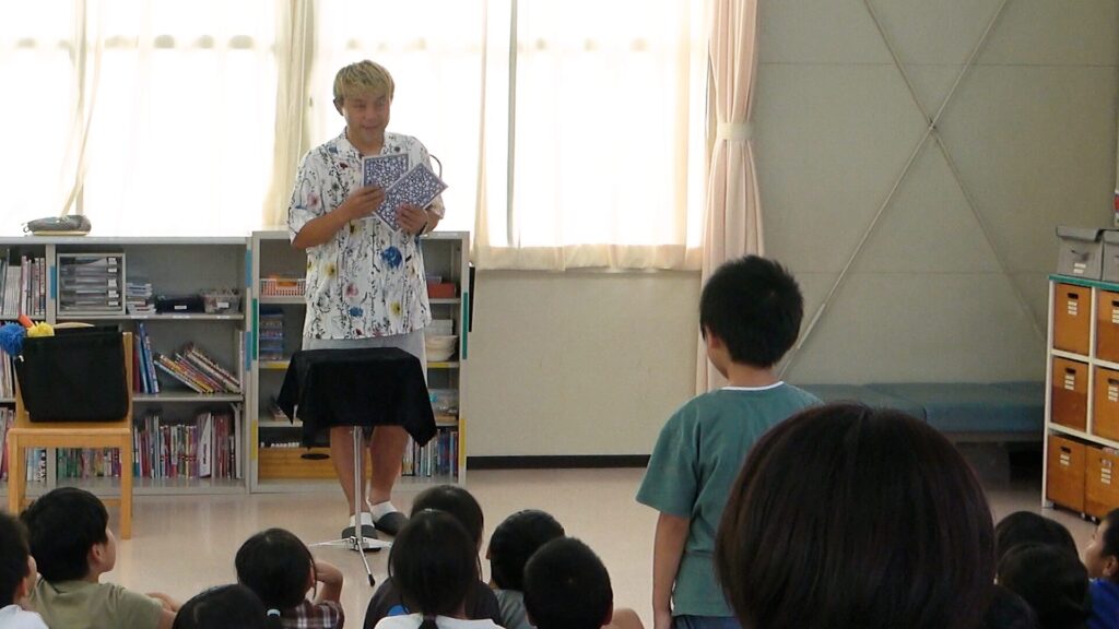 高岡市の学童保育で行われたマジックショー。子どもが前に出てカードマジックに参加している様子。