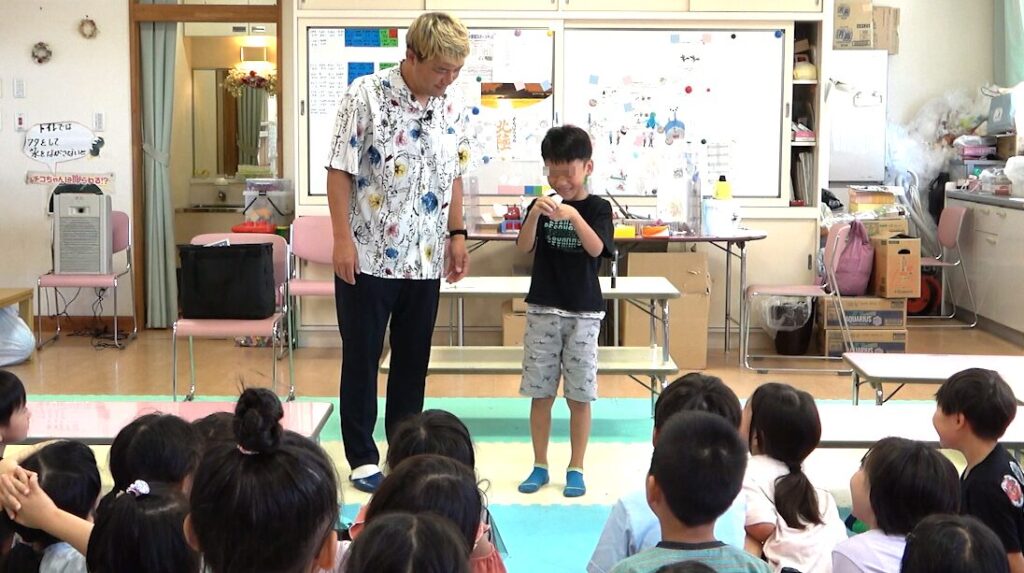 マジシャンコンプレッサーと一緒にマジックに挑戦する射水市の学童保育の児童の様子