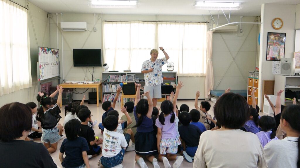 高岡市の学童保育で開催されたマジックショーの様子。子どもたちが前のめりに参加しているシーン。