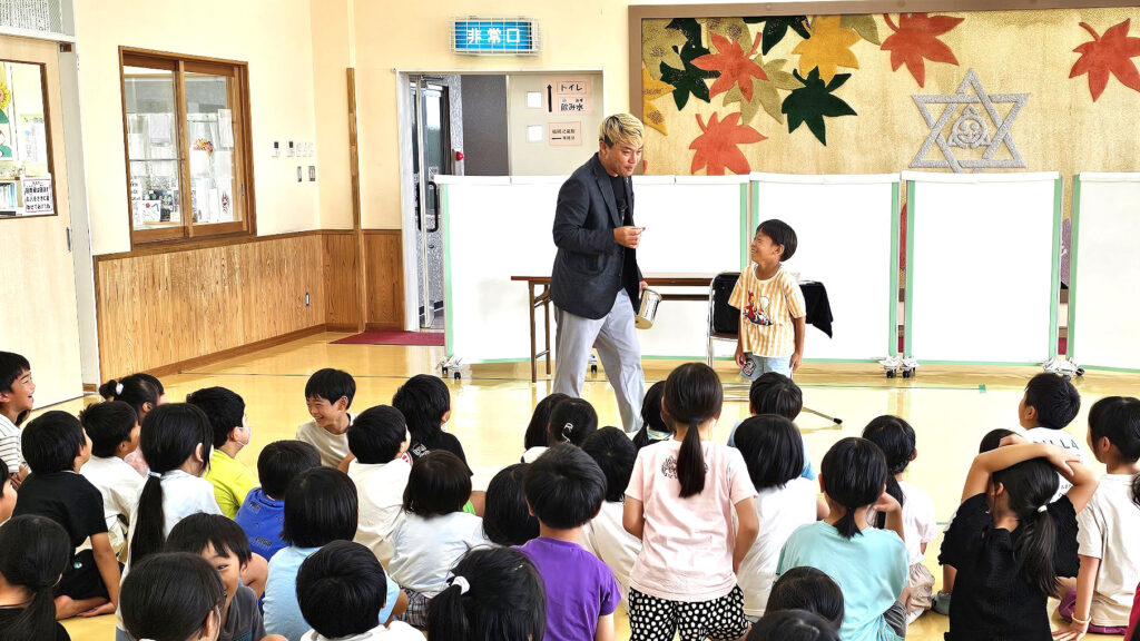 「学童保育 マジックショー 出張」福岡町・さくら会館で17年連続出演 7 学童保育 マジックショー 出張で児童と一緒にコインマジックを披露する様子(福岡町・さくら会館)