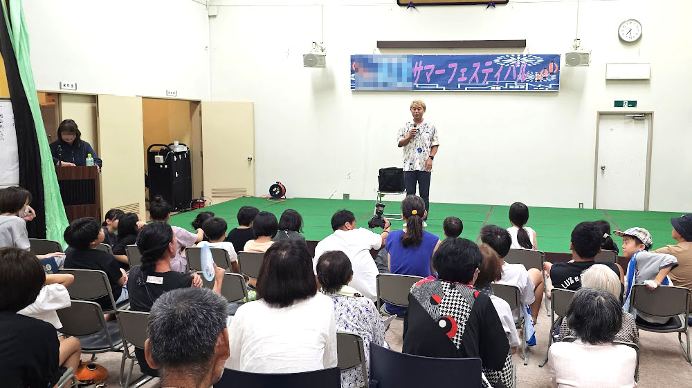 納涼祭マジックショー時間 屋内ステージで観客に語りかける開演挨拶の場面
