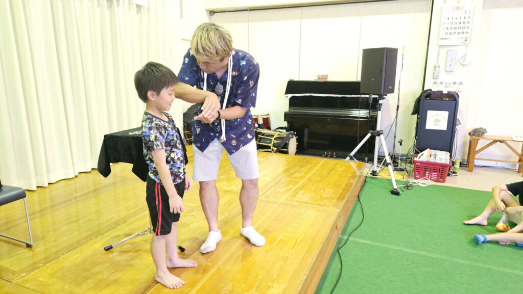 富山県南砺市の納涼祭マジックショーで子どもと一緒にステージを盛り上げる様子　古典マジック「ロープマジック」を演じている。