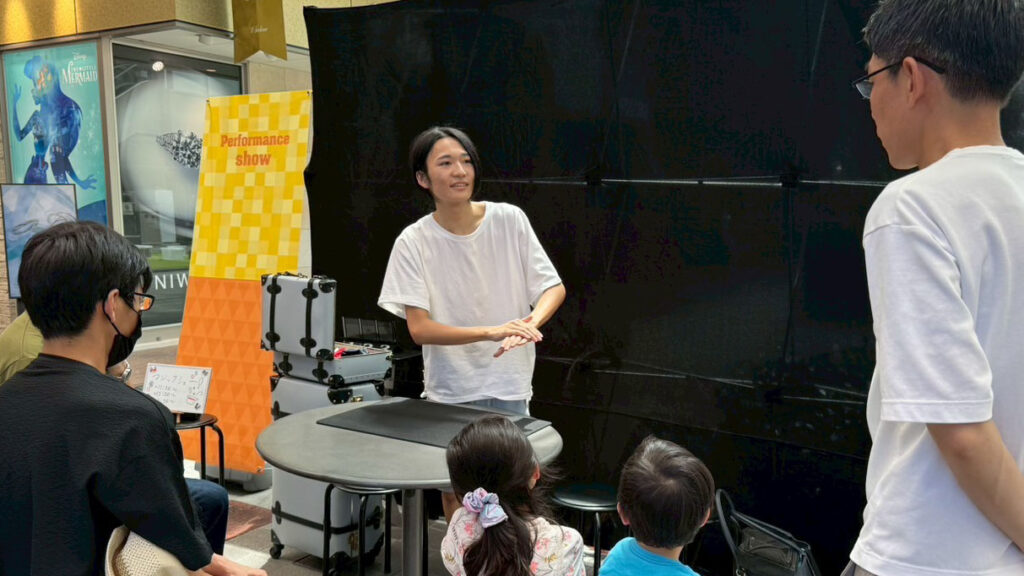 富山ストリートパフォーマンスで若いマジシャン　ようすけ　が観客に向けて手品を披露している様子