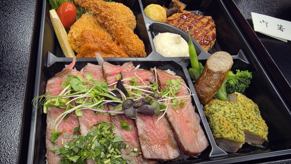 富山の企業パーティーで提供された、ローストビーフやエビフライが入った豪華な仕出し弁当。