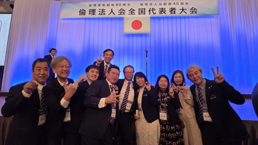 倫理法人会 全国代表者大会の壇上で、富山県倫理法人会のメンバーが全国第1位の受賞を喜ぶ記念写真