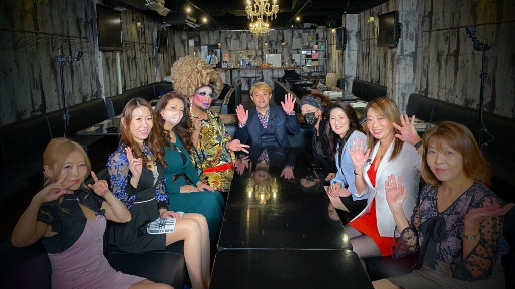 マジシャン コンプレッサーが富山テレビの番組「桜木町ナイトスナッカーズ」の収録で出演者とテーブルを囲む様子