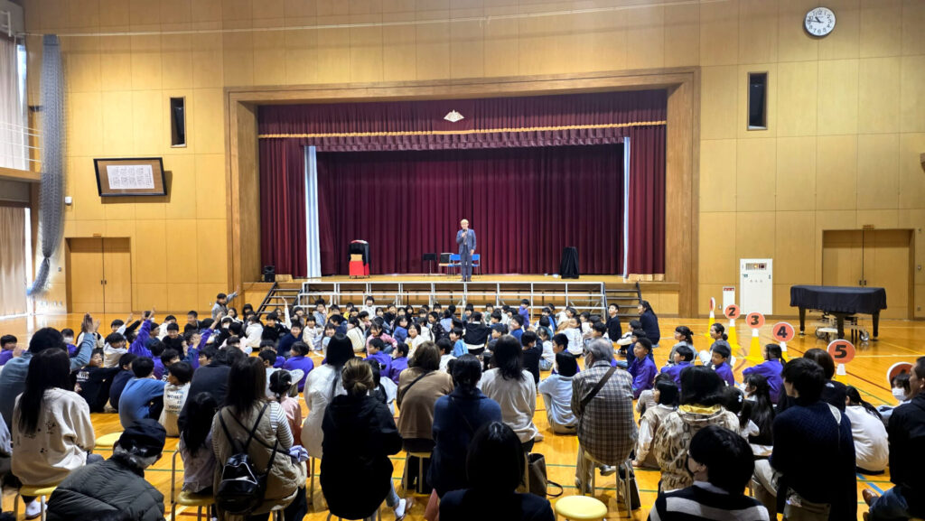 学習発表会のマジックショーで元気に手を挙げて参加する立山北部小学校の子供たち