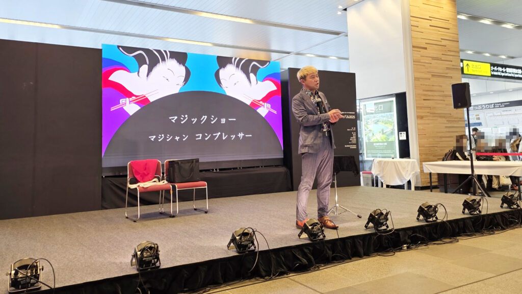 富山駅のイベントステージで、軽快なトークと共にマジックを披露するマジシャン・コンプレッサー