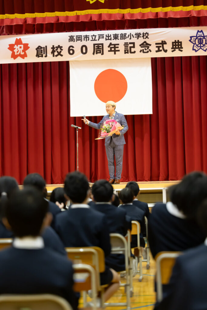 創立60周年の節目を祝い、ポーズを決めるマジシャン・コンプレッサーと華やかなステージ