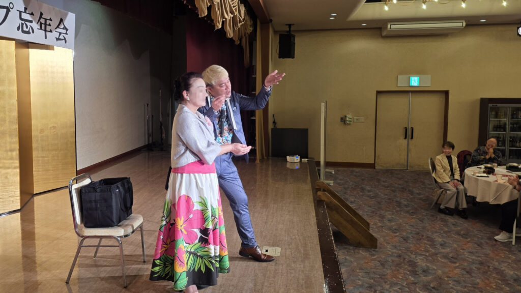 くつろぎの宿 うみあかりのステージにて、女性のお客様を客上げして一緒に驚きの瞬間を演出し、会場全体を笑顔にするマジシャン・コンプレッサー