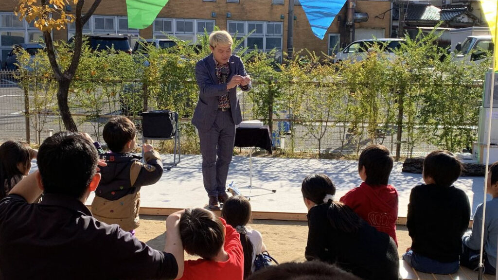 金沢市の幼稚園の屋外ステージでマジックショーを行うマジシャン「コンプレッサー」