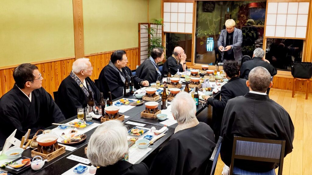 お食事中の皆様のすぐそばで、トランプマジックを披露するマジシャン・コンプレッサー。和やかな会食の席に驚きと笑顔をお届けしている様子。