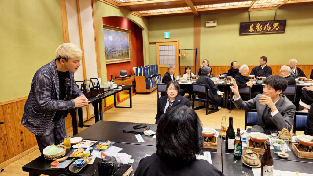 お席を回り、お子様や若い世代の皆様の目の前でマジックを演じるコンプレッサー。驚きの表情を浮かべる参列者と、一体感のあるショーのワンシーン。