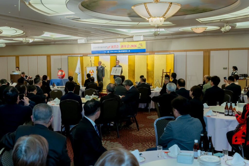 富山県倫理法人会 日本一祝賀会で県旗を掲げるマジシャン・コンプレッサー