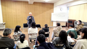 児童クラブでのマジックショーで笑顔になる観客の親子たち