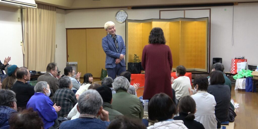 石川県羽咋市の演芸会で、お客様とともにマジックを楽しむコンプレッサー。20周年に向けた新たな挑戦が、会場の笑顔を引き出します。
キャプション: 楽しい掛け合いで、会場中が驚きと笑顔に包まれる和やかなワンシーン。