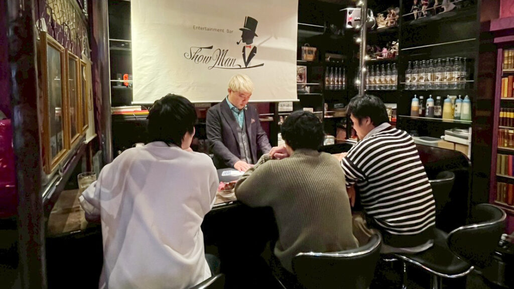 富山桜木町のマジックバー・ショーマンでカウンター越しにテーブルマジックを披露するマジシャン・コンプレッサー
至近距離で繰り広げられる驚きのマジックにお客様も身を乗り出して見入っています