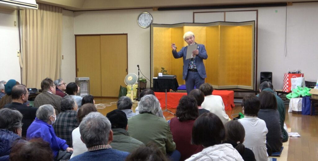 芸歴20周年に向けた新作マジック「読心術」にご来場のお客様もくぎ付け。見事に相手の心を読み取り、会場が大いに沸き上がる石川県でのステージ。 キャプション: 失敗から学んだ渾身の新作「読心術」が見事に大成功し、会場が沸く瞬間！