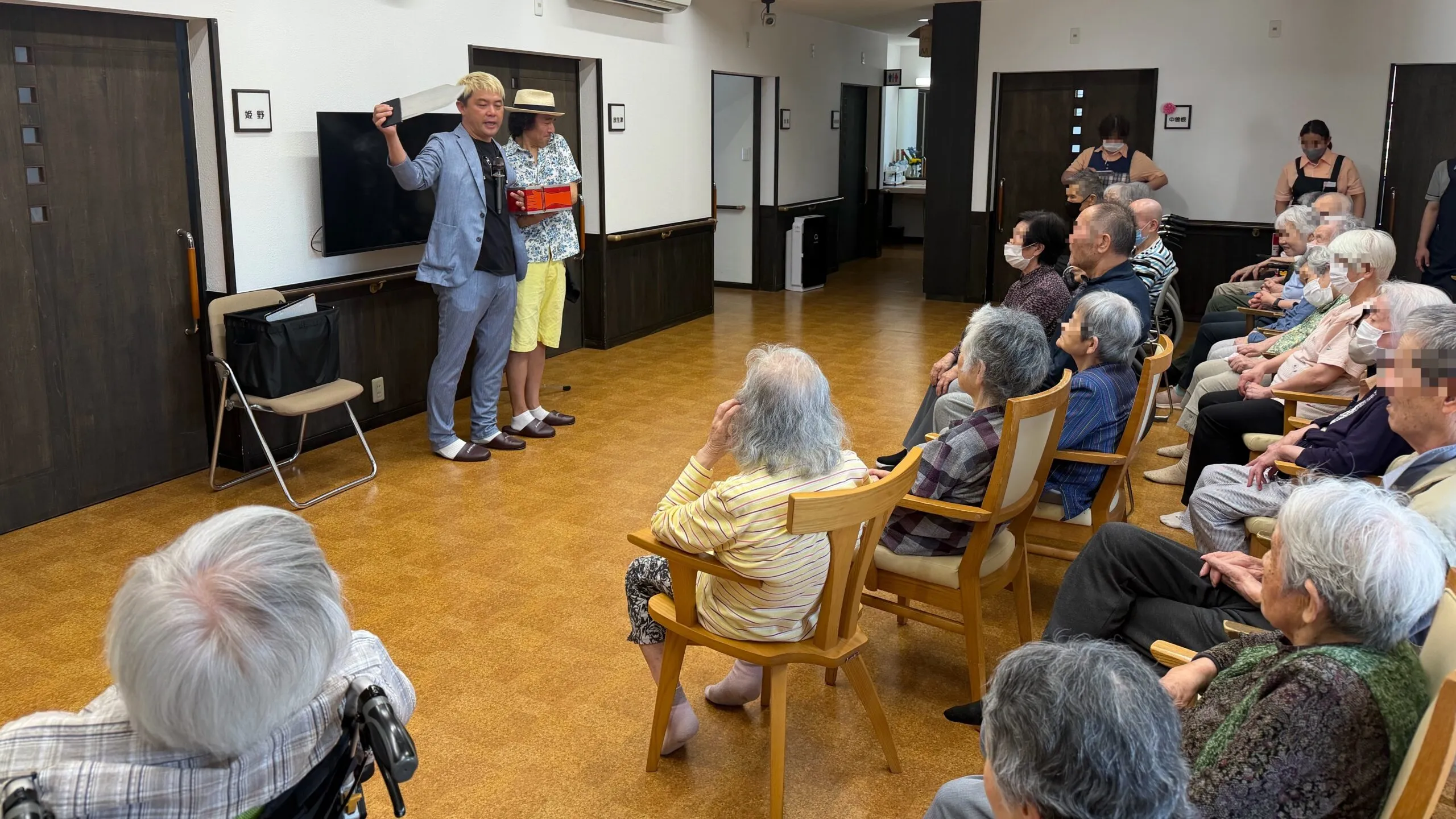 ケアホームなかそねの利用者さんをステージ前にお招きして一緒にマジックを演じるマジシャン・コンプレッサー