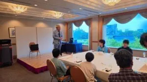 富山のANAクラウンプラザホテル富山4階の宴会場で、窓の外に富山城を望みながらサロンショーを行うマジシャン・コンプレッサー