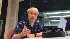 FMとやまのスタジオでヘッドホンを着け、マイクに向かって話すマジシャン・コンプレッサー