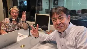 FMとやまのスタジオで、富山大和の青山さんと並んでピースサインをするマジシャン・コンプレッサー