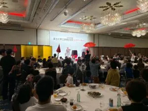 富山のホテルグランテラス富山のビアパーティーで赤い傘を使ったステージマジックを披露するマジシャン・コンプレッサー