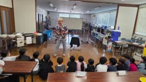 氷見市のビバふじみだい児童育成クラブ10周年記念行事で子どもたちの前に立つマジシャン・コンプレッサー
