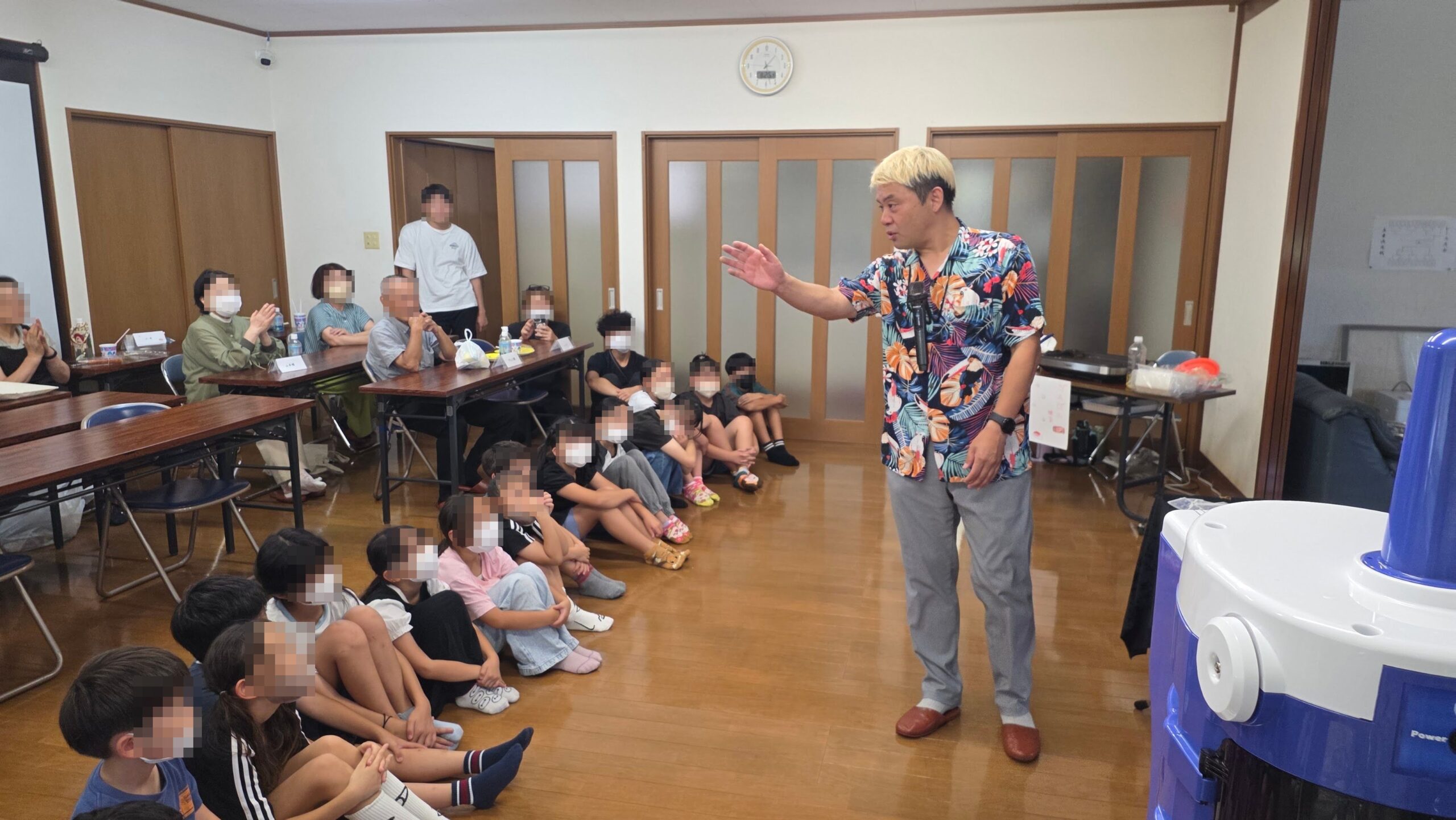氷見市の学童保育10周年記念行事で床に座りマジックショーへ集中する子どもたちと来賓の皆さま