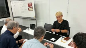射水市のマジックサークルまじっぱ130回目。紙のマジックを演じるマジシャン・コンプレッサーと、一緒に紙を折るメンバー