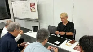 射水市のマジックサークルまじっぱ130回目。紙のマジックを演じるマジシャン・コンプレッサーと、一緒に紙を折るメンバー