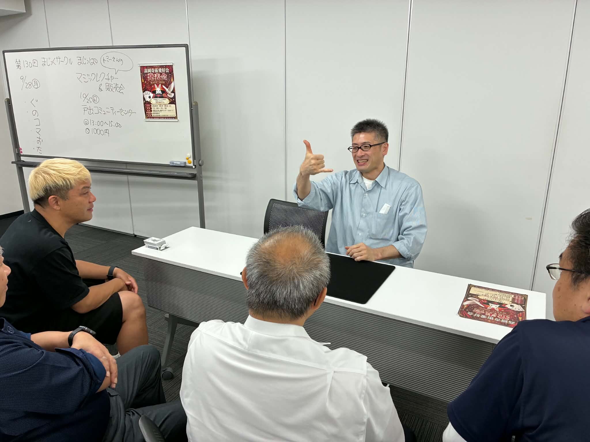 演者の席で手ぶりを交えて話すメンバーと、客席で聞くマジシャン・コンプレッサー｜射水市のマジックサークル