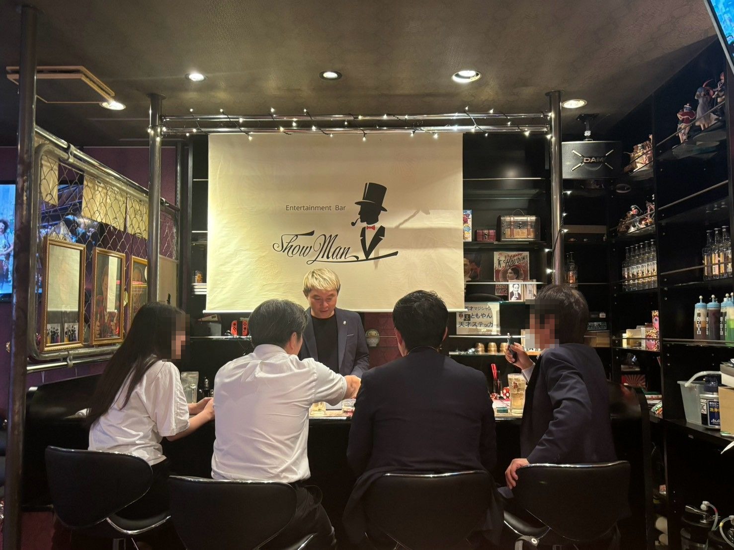 富山桜木町 マジックバー ショーマン|2週続けて出演、20年前の夢が"ホーム"になった夜 3 マジックバー ショーマンのカウンターで、4名のお客さまに向けてテーブルマジックを演じるマジシャン・コンプレッサー