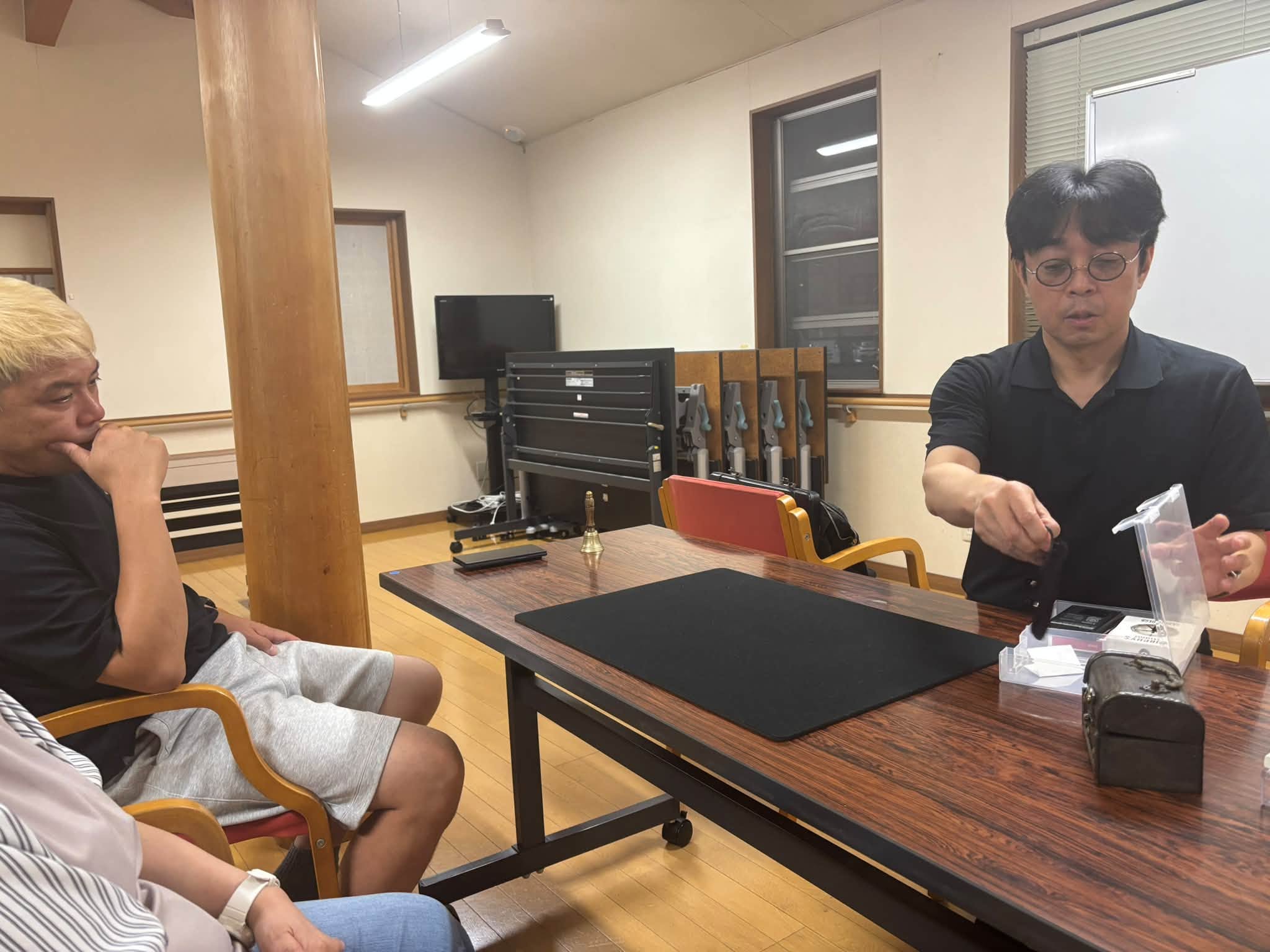 マジック研究会でベルと数字を使ったメンタルマジックを披露する所属マジシャン