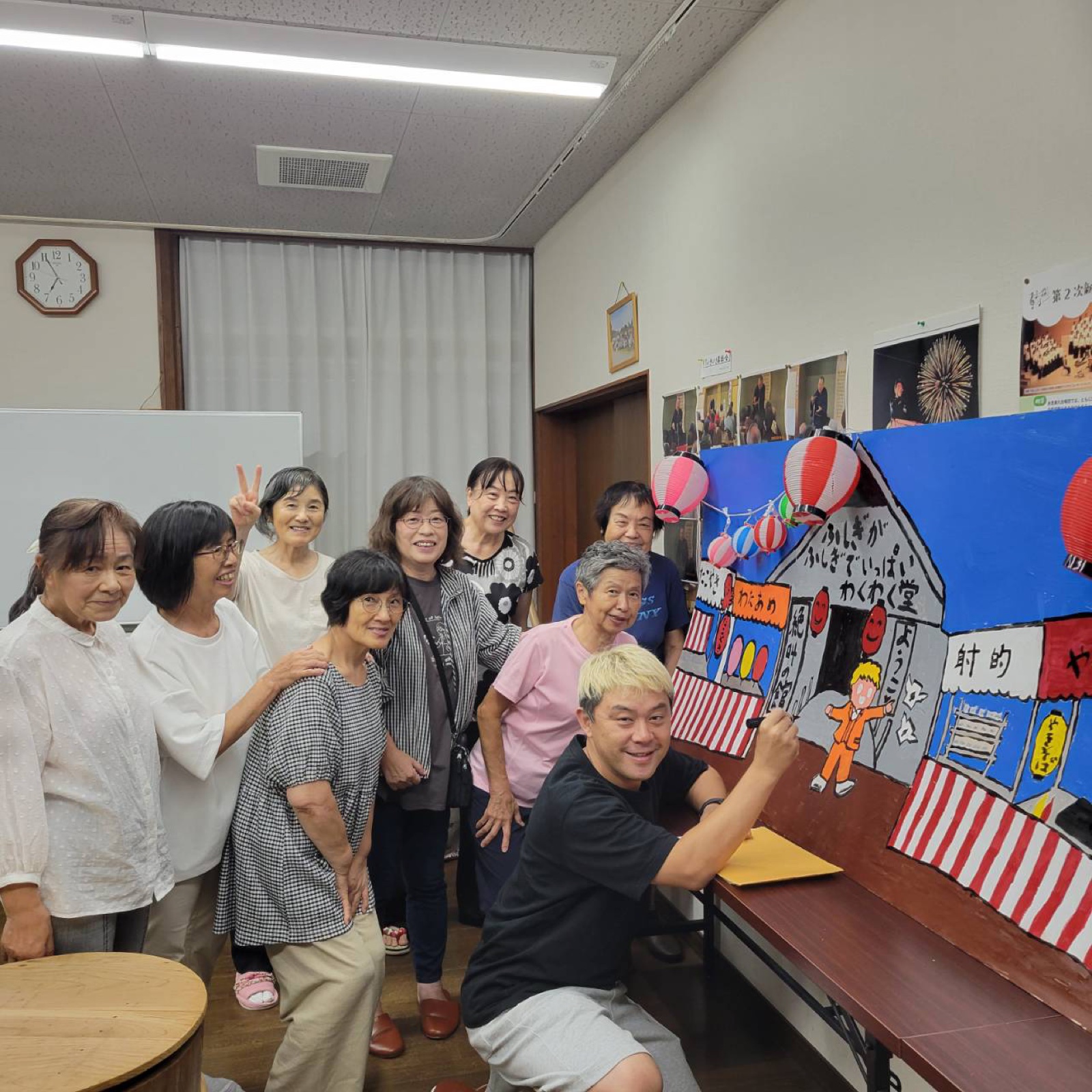 愛の劇団の稽古場で満面の笑顔と拍手で目入れ式を見守る団員の皆さん