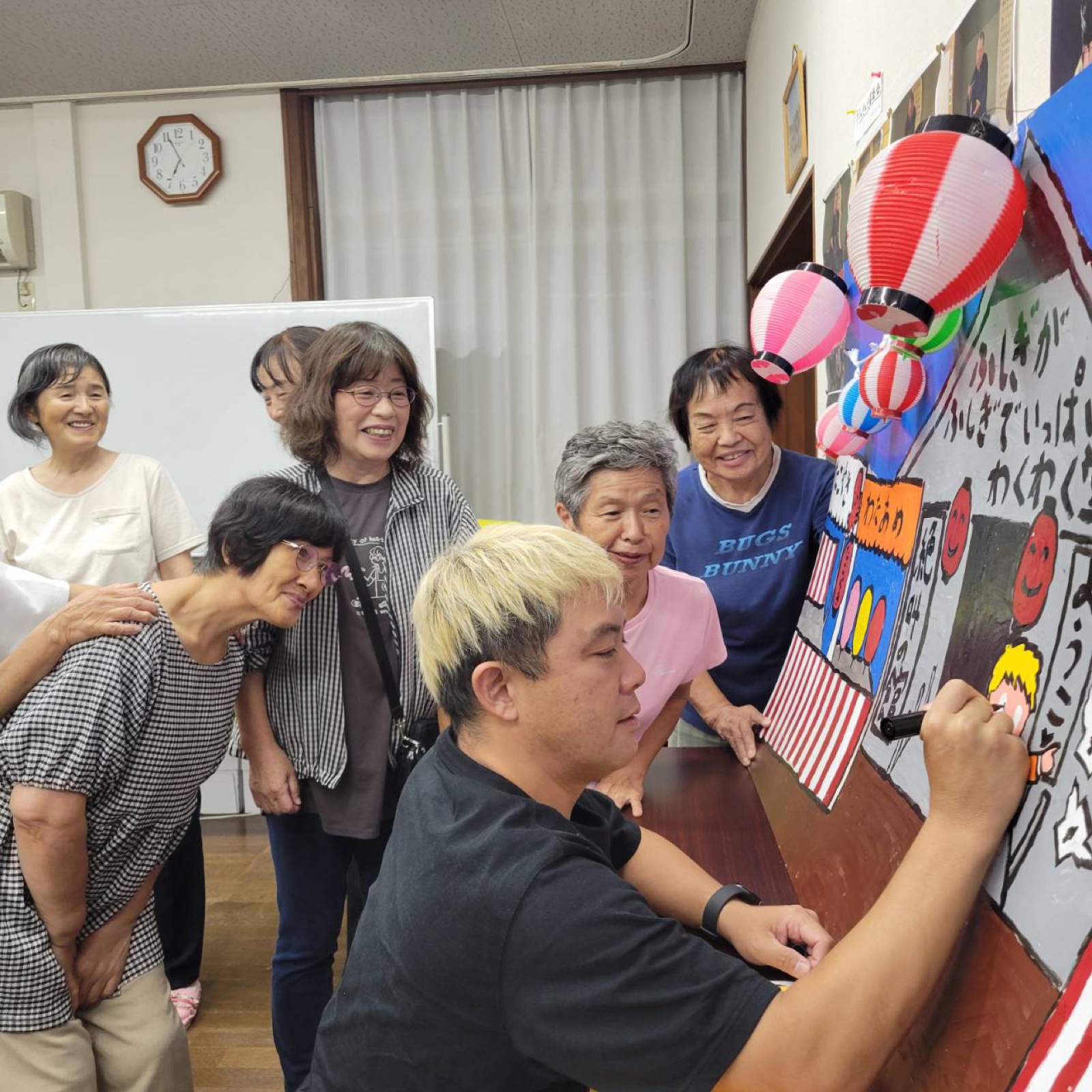 劇団員の皆さんが見守るなか目入れ式を進めるコンプレッサー