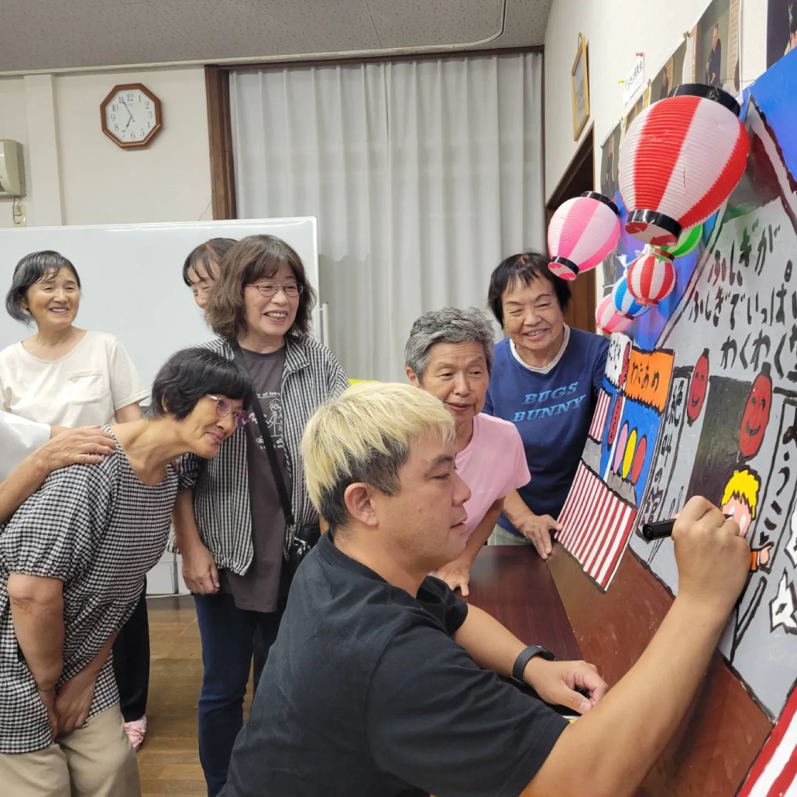 劇団員の皆さんが見守るなか目入れ式を進めるコンプレッサー