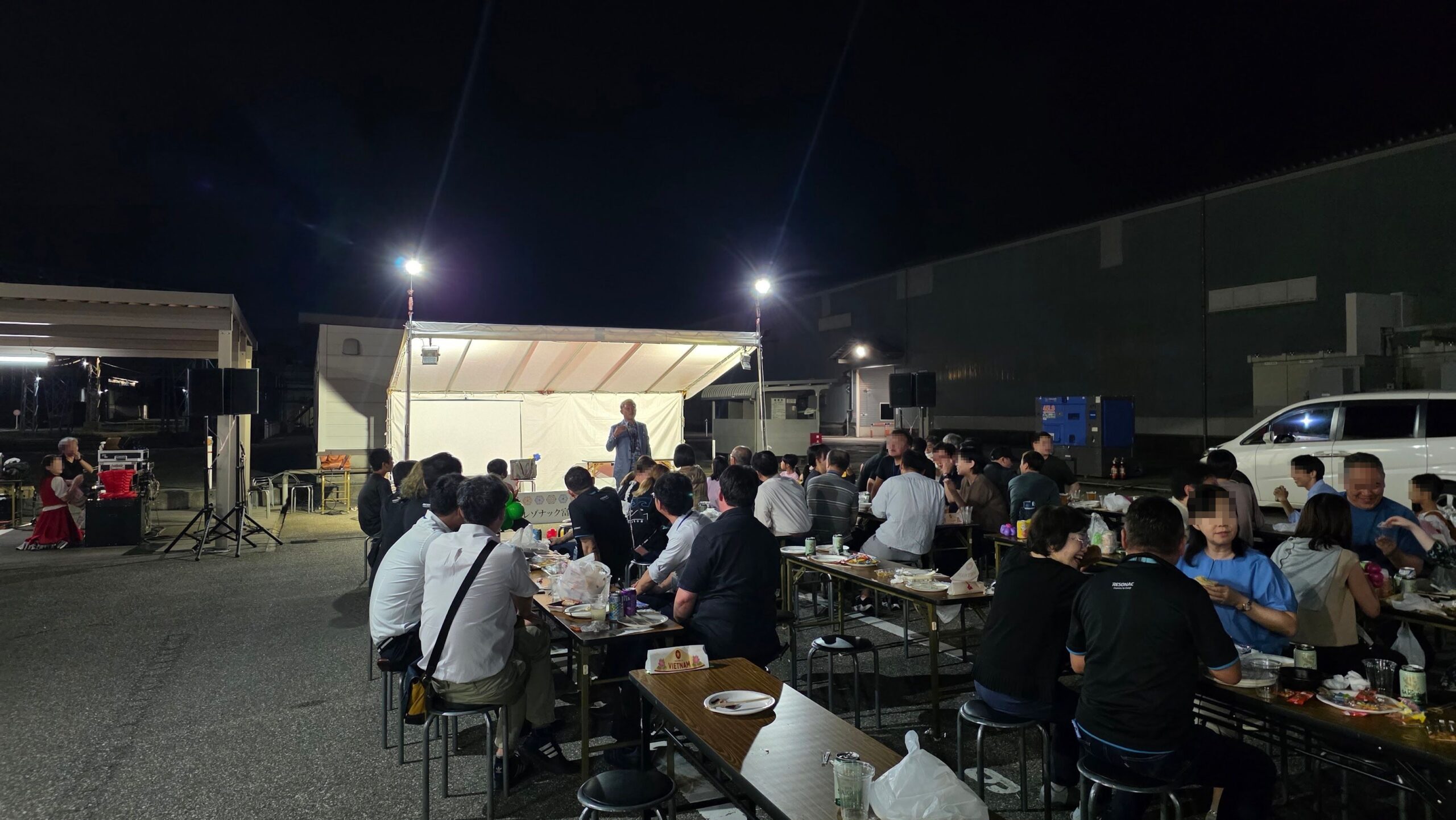 レゾナック富山事業所の秋祭り会場全景とステージ前で演じるマジシャン・コンプレッサー