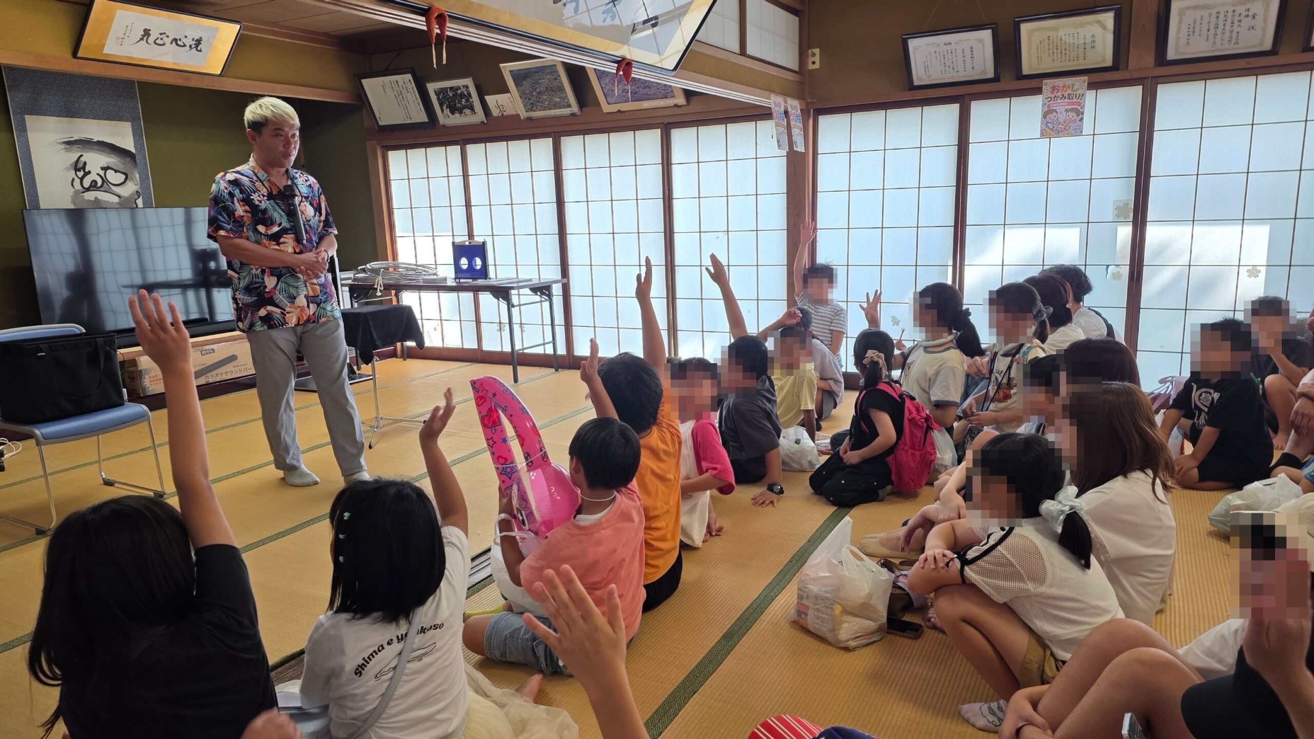 高岡市の子供イベントでマジックショー|みんなで挑戦した約50分 1 畳の部屋に集まった子どもたちが元気よく手を挙げる中、マジックショーを進めるマジシャン・コンプレッサー