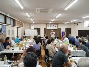 高岡市内の公民館で開かれた敬老会のマジックショーで客席へ語りかけるコンプレッサー