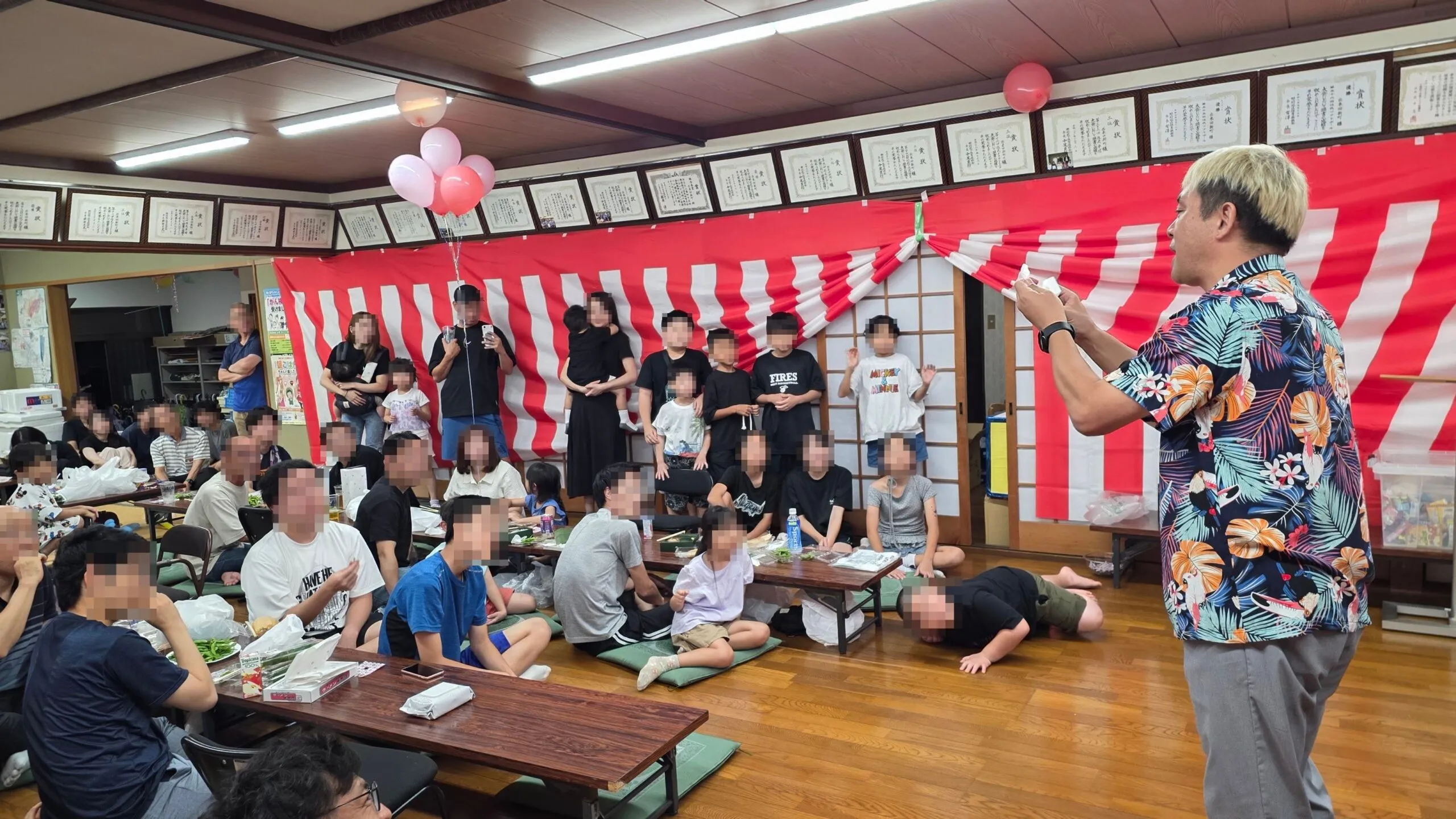 高岡市の納涼祭で白い紙を手に演じるコンプレッサーと公民館の観客