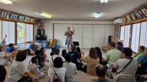 富山市新庄町の夏祭りで子どもと大人が手を挙げるマジックショー