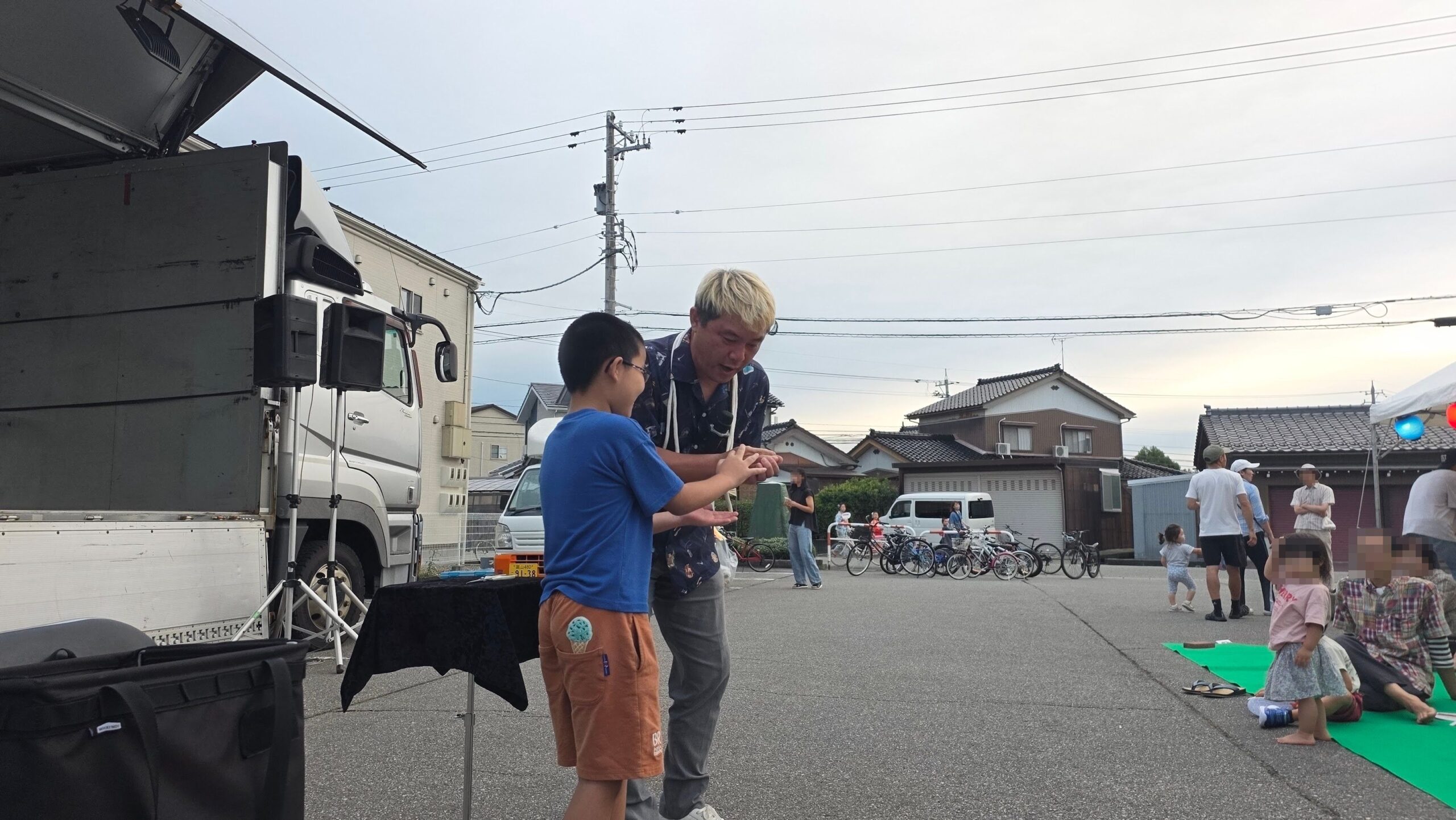 富山市の夏祭りで、子どもと一緒に屋外マジックを進めるコンプレッサー