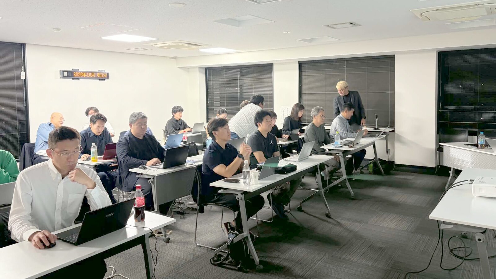 AIエージェント講座で、参加者の席まで行ってパソコンの画面を一緒に確かめるコンプレッサー