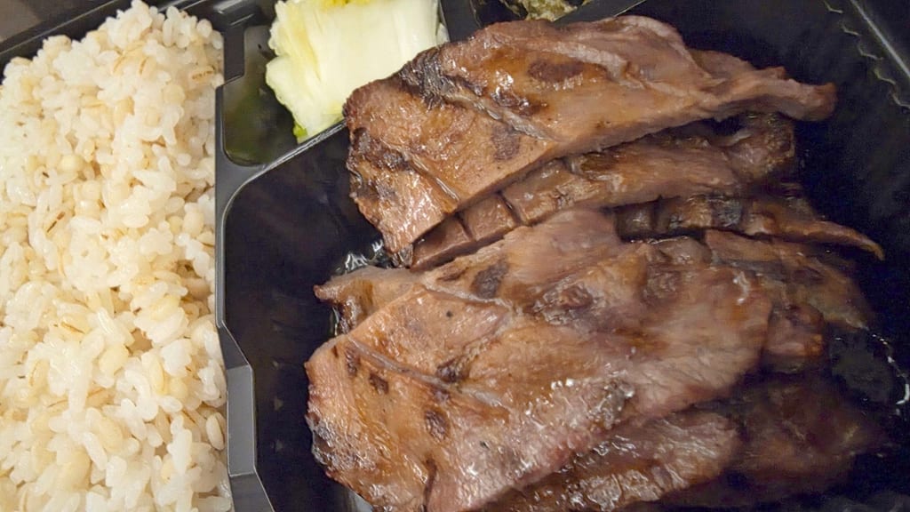 帰りの東北新幹線で食べた牛たん弁当。麦ごはんの横に、焼き目のついた厚切りの牛たんが並んでいる