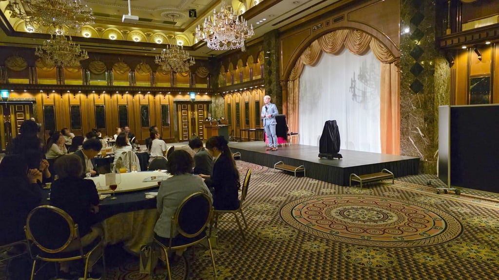 姫路市の結婚式場のステージに立ち、円卓の客席に向かって話しかけるコンプレッサー