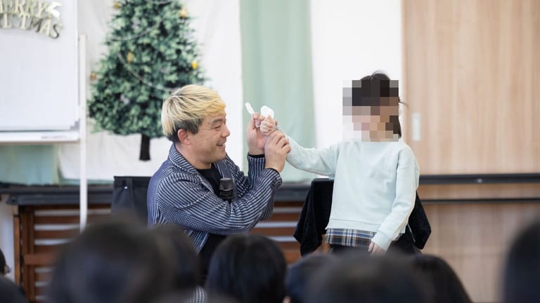 クリスマスツリーの前で、お手伝いの女の子と一緒にマジックをするコンプレッサー