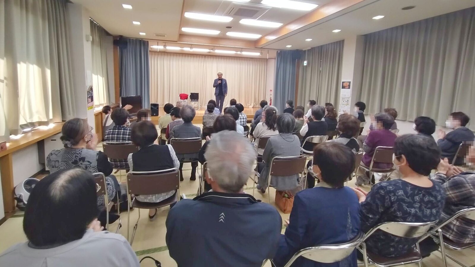 小矢部市のいきいきサロンのマジックショーで、ステージのコンプレッサーに拍手を送る客席の皆さん