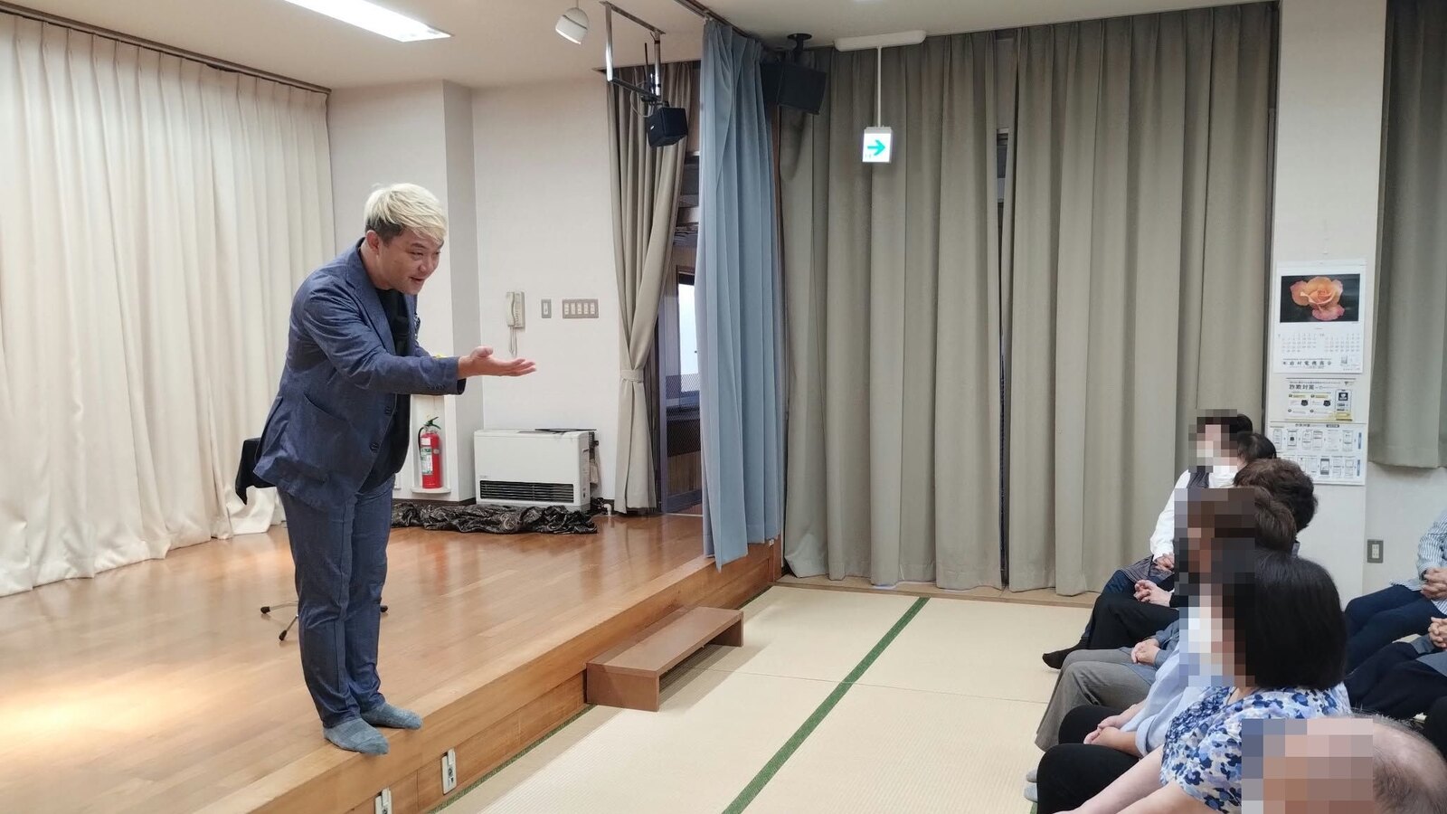 小矢部市の若林公民館のいきいきサロンで、ステージの端からいちばん前のお客さまに話しかけるコンプレッサー